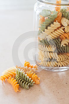 Raw fusilli pasta with glass bottle