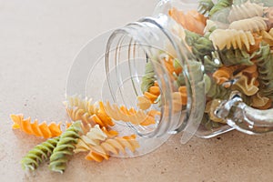 Raw fusilli pasta with glass bottle