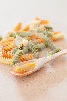 Raw fusilli pasta with wooden spoon