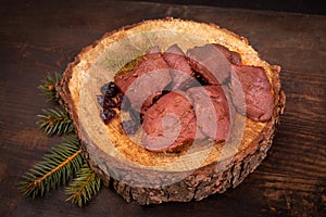 Raw game meat, beef on chopping block, wood slice. Steaks, pieces of red meat on wood. High quality roe, deer meat. photo