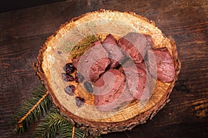 Raw game meat, beef on chopping block, wood slice. Steaks, pieces of red meat on wood. High quality roe, deer meat. photo