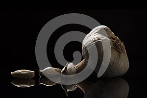 Raw Garlic cloves on glass black