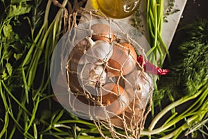 Raw Garlic, onion, dill and parsley for soup for dinner on the wooden table background. Rustic food styling. Natural