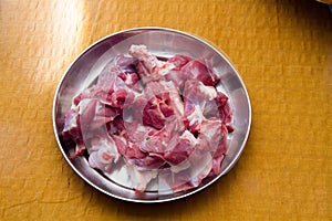 Raw goat red meat pieces in a steel plate