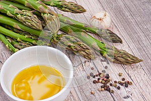 Raw green asparagus stems on a wooden surface