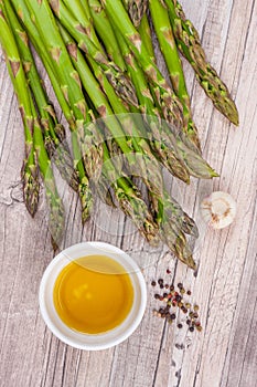 Raw green asparagus stems on a wooden surface, flat lay