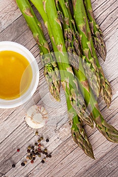 Raw green asparagus stems on a wooden surface, flat lay