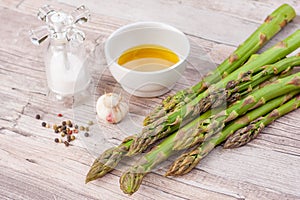 Raw green asparagus stems on a wooden surface, flat lay