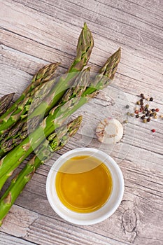 Raw green asparagus stems on a wooden surface, flat lay