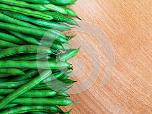 Raw green beans on wood background, close up, top view, copyspace