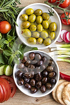 Raw green and black olive seeds and vegetables