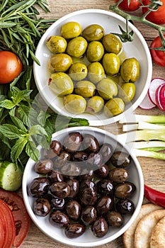 Raw green and black olive seeds and vegetables