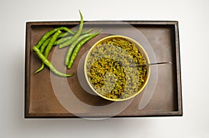 Raw Green Chilli pickle,  Mirchi  Achar placed on a wooden Tray.