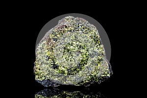 Raw green epidote mineral stone on mother rock in front of black background