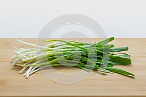 Raw green garlic on cutting board preparated for cooking