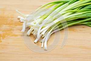 Raw green garlic on cutting board preparated for cooking