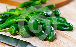 Raw green spanish Padron peppers on table photo