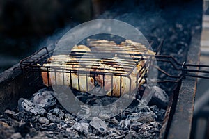 Raw Grilled chicken Leg on grill, over coals with smoke