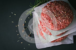 Raw ground beef burger patties separated by baking paper