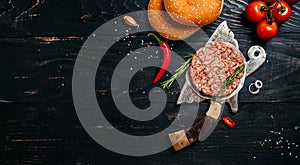 Raw Ground beef lamb meat Burger steak cutlets on dark wooden background with meat cleaver. Long banner format. top view