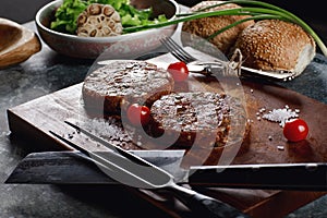 Raw Ground beef meat Burger steak cutlets with ingredients on the board.