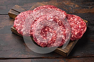 Raw Ground beef meat Burger steak cutlets, on old dark  wooden table background