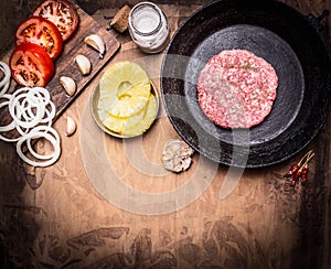 Raw Ground beef meat Burger steak cutlets in pan with vegetables, spices border ,with text area wooden rustic background top vi