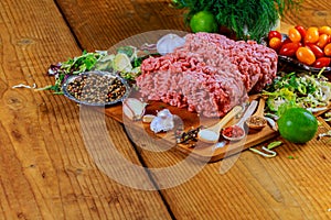 Raw Ground beef meat Burger steak cutlets with seasoning, tomatoes,