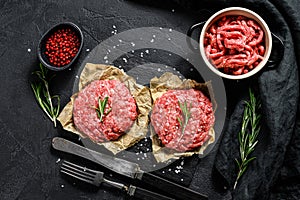 Raw Ground beef meat Burger steak cutlets and seasonings. Farm organic meat. Black background. Top view