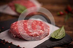 Raw ground beef meat burger steak cutlets on wooden background