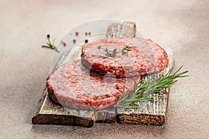 Raw Ground beef meat Burger steak cutlets on a wooden board, Food recipe background. Close up