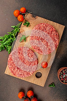 Raw Ground beef meat Burger steak cutlets on a wooden board, Food recipe background. Close up