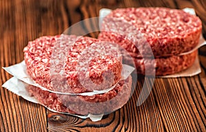 Raw ground beef meat hamburger patties on paper, photo