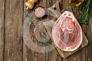 Raw ham cut, pork leg on a wooden background, banner, menu, recipe place for text, top view