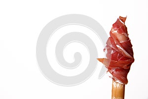 Raw ham rolled up on a breadstick