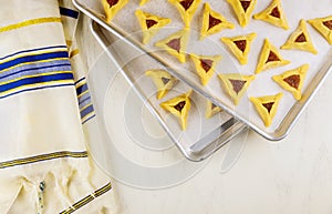 Raw hamantaschen cookies on baking tray with tallit