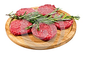 Raw hamburgers with cellophane and rosemary on wooden board