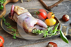 Raw hazel grouse with vegetables on a wooden board