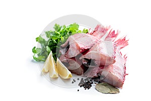 Raw headless gutted redfish with herbs and lemon isolated on white