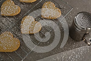 Raw heart shape cookies with sugar icing on baking tray