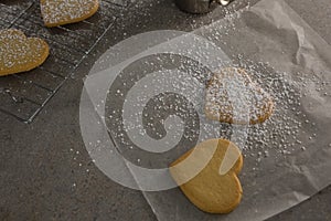 Raw heart shape cookies with sugar icing on wax paper