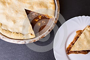 Raw homemade apple pie with cinnamon and walnuts, closeup