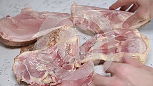 Raw homemade chicken meat is laid out by hand on the table.