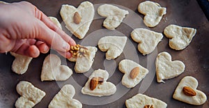 Raw homemade heart-shaped cookies on a baking sheet. Concept of fresh pastry, surprise for Valentine`s day