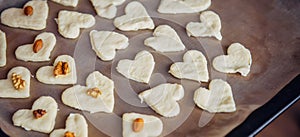 Raw homemade heart-shaped cookies on a baking sheet. Concept of fresh pastry, surprise for Valentine`s day