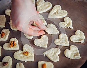 Raw homemade heart-shaped cookies on a baking sheet. Concept of fresh pastry, surprise for Valentine`s day