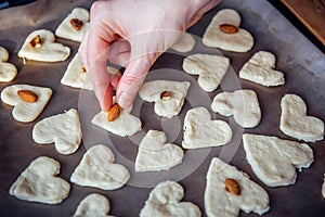 Raw homemade heart-shaped cookies on a baking sheet. Concept of fresh pastry, surprise for Valentine`s day