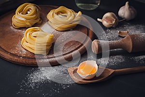 Raw homemade pasta with flour and spices on the rustic background.