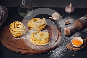 Raw homemade pasta with flour and spices on the rustic background.