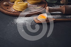 Raw homemade pasta with flour and spices on the rustic background.